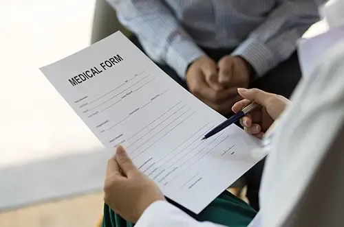 Person reviewing a medical form during a disability evaluation